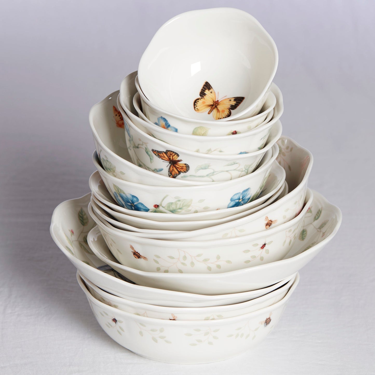 Stack of ceramic bowls with butterfly designs on a light gray background