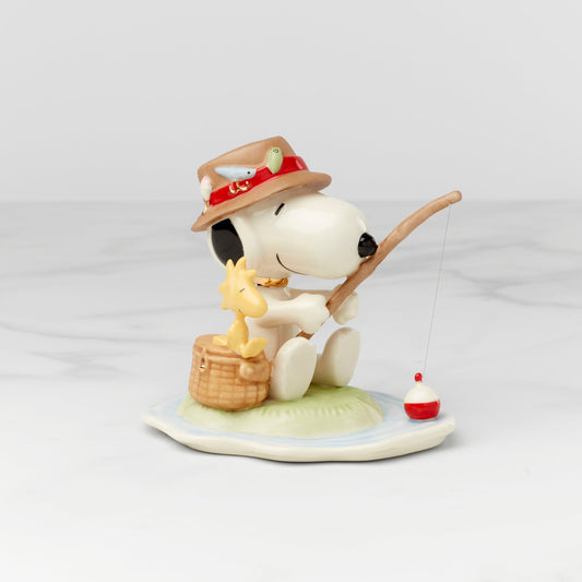 Snoopy fishing figurine with a dog and a basket on a white background